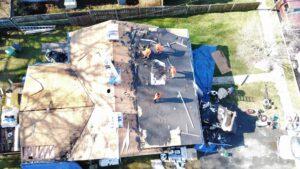 Excel Roofing doing a roofing tear-off for a customer with tarping to protect the property