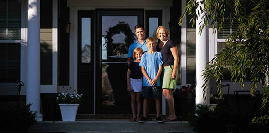 Family in front of their home covered with a roof warranty